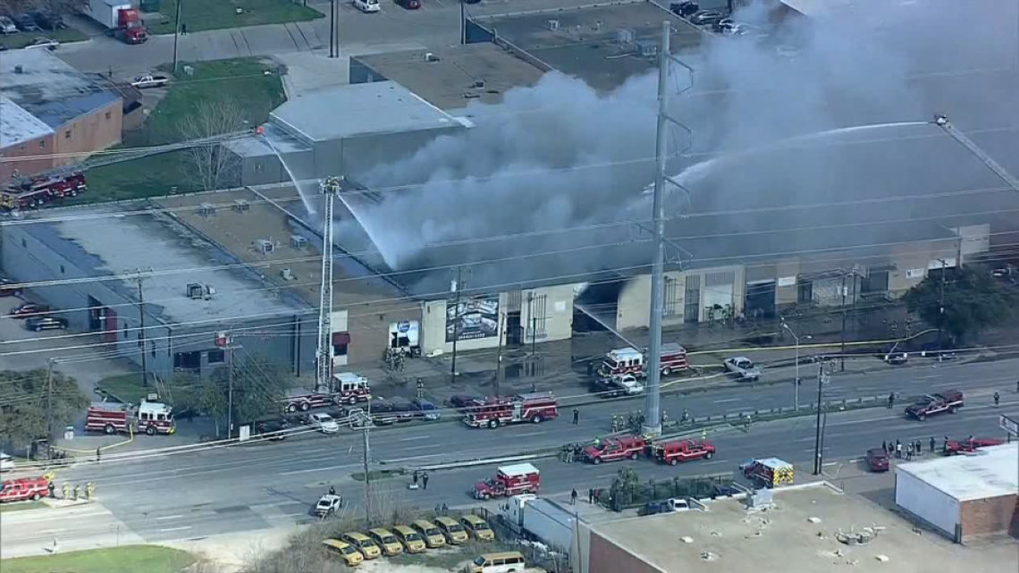 Bomberos trabajan en incendio de almacén