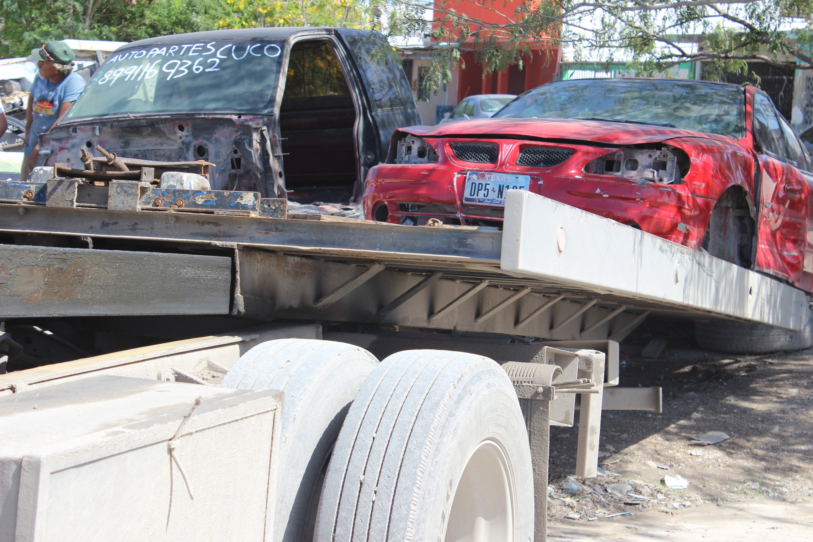 Retiran vehículos desmantelados por invadir vía pública