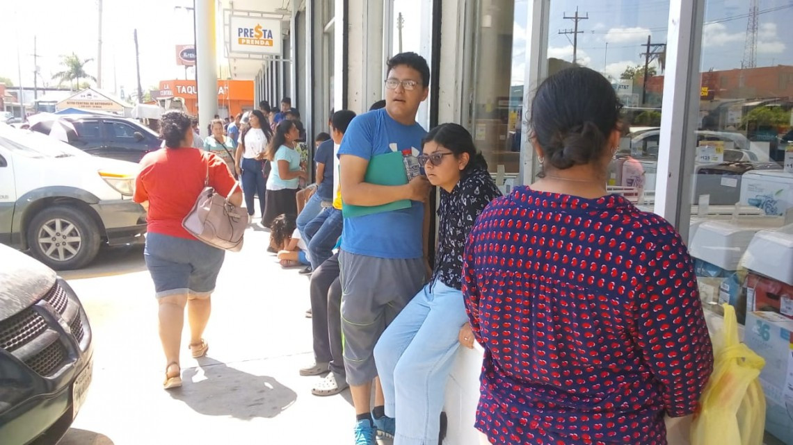 Bajo los rayos del sol y una sensación de 42 centígrados jóvenes esperan por su beca