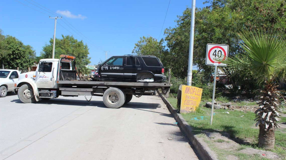 Retiran vehículos desmantelados por invadir vía pública