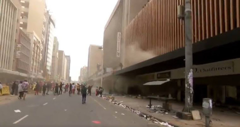 Por disturbios en Sudáfrica, mujer arroja a su bebé por la ventana de un edificio en llamas