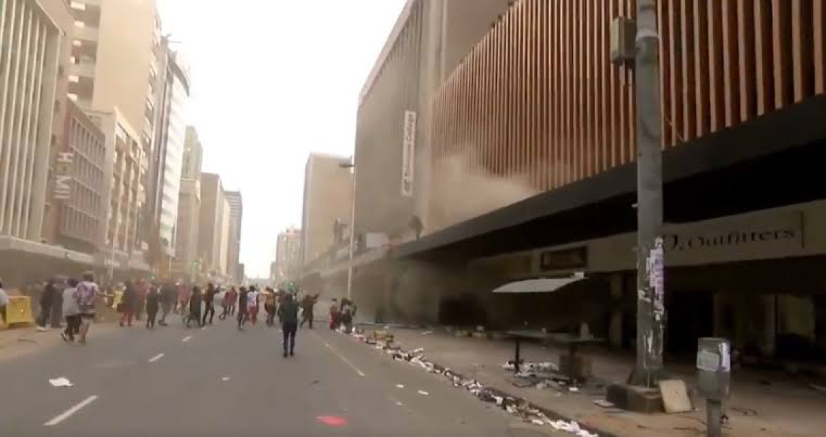 Por disturbios en Sudáfrica, mujer arroja a su bebé por la ventana de un edificio en llamas