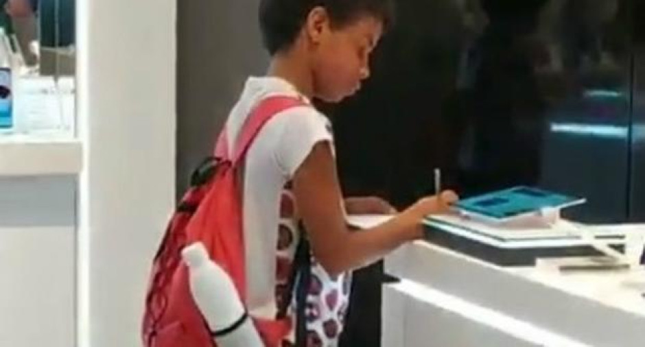 Niño usa tablet de tienda comercial para hacer su tarea